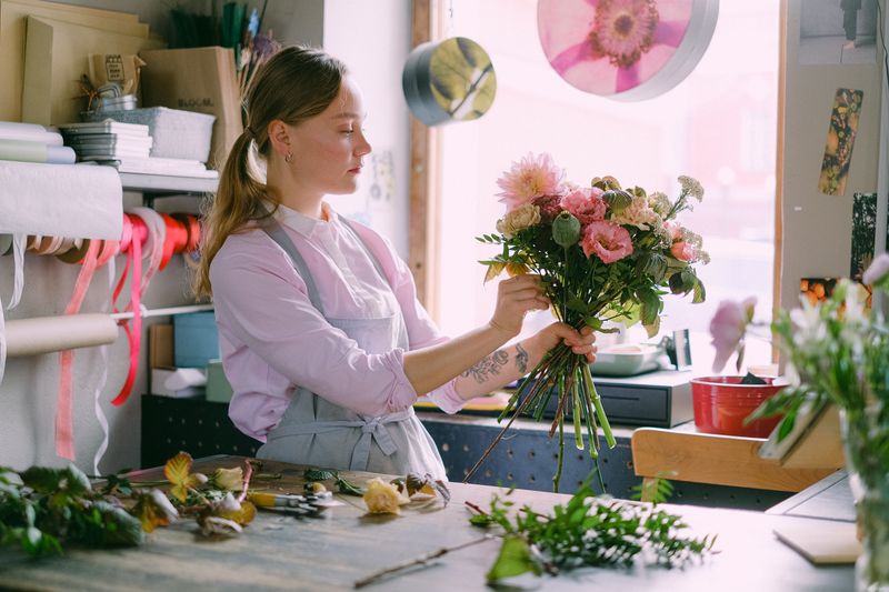 Fleuriste Interflora préparant un bouquet avec soin
